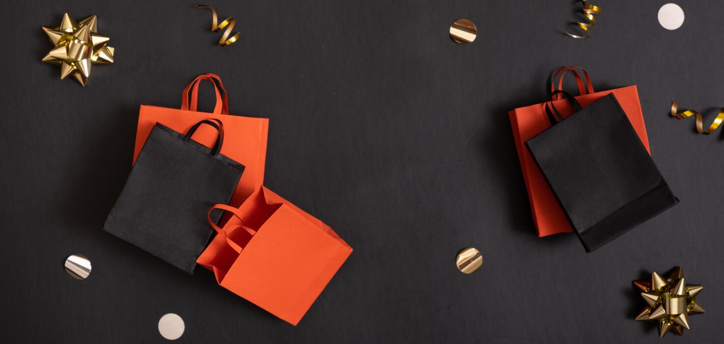 black-friday-banner-sale-concept-red-and-black-paper-shopping-bags-with-decorations-on-black-background-photo